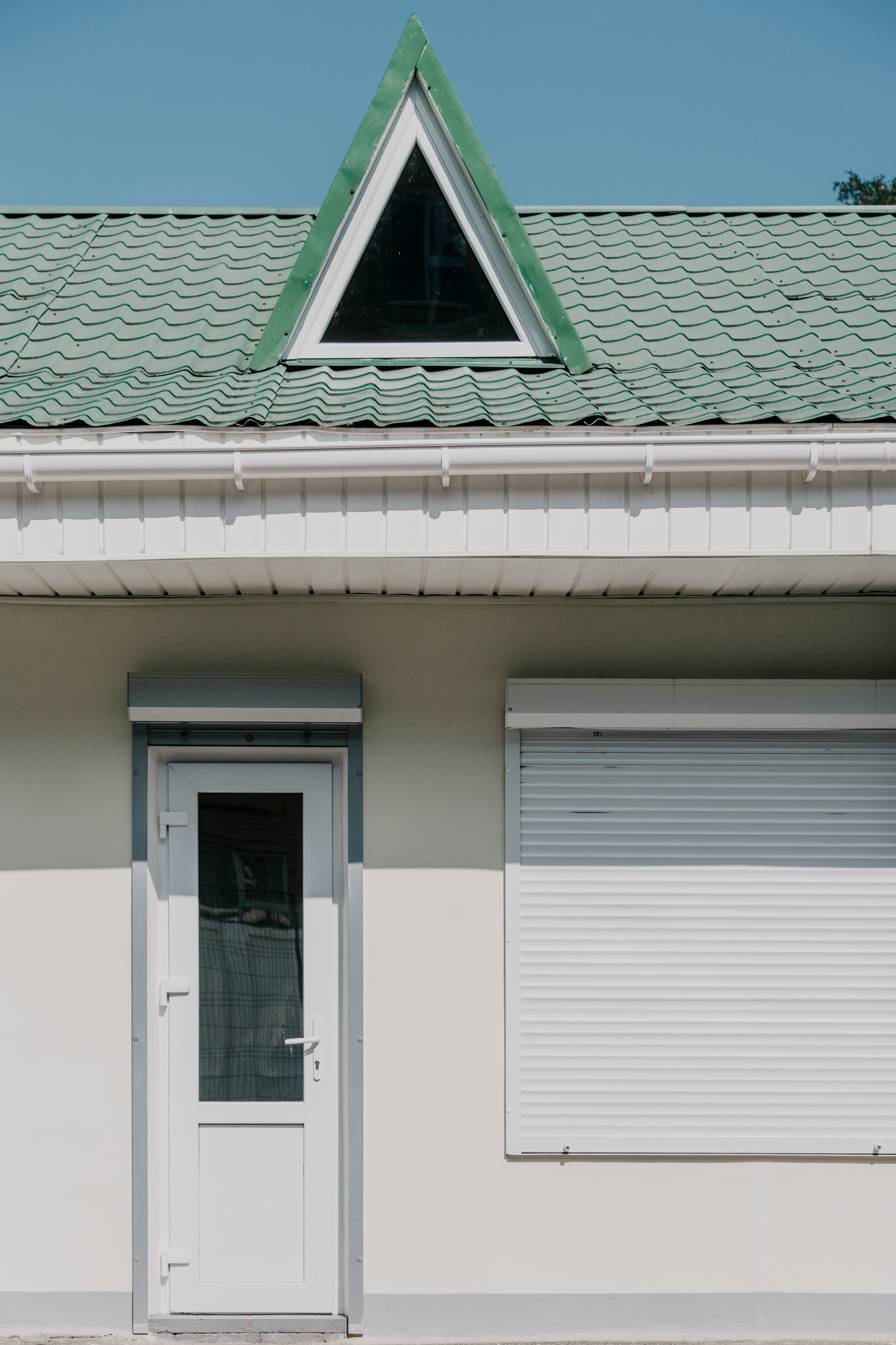 white wooden door and green house roof